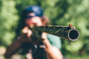 A person aiming a shotgun
